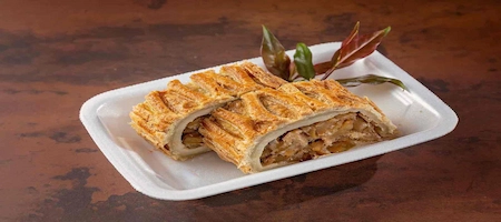 Apfelstrudel slices with golden pastry and apple filling on a white plate