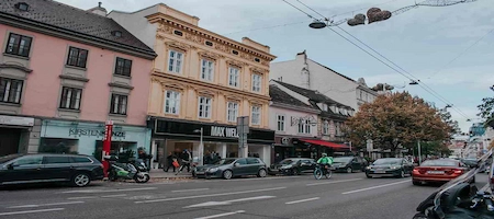 Shops, colourful façades and a cyclist on a Vienna street