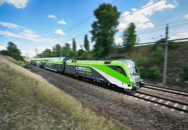 Vienna’s green and white City Airport Train (CAT) travelling along railway tracks