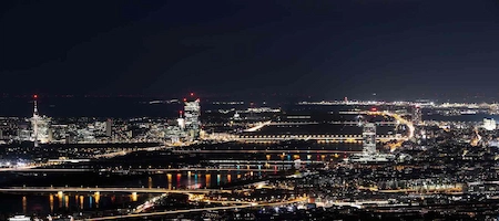 Night view of Vienna with the Danube River, illuminated bridges and city lights