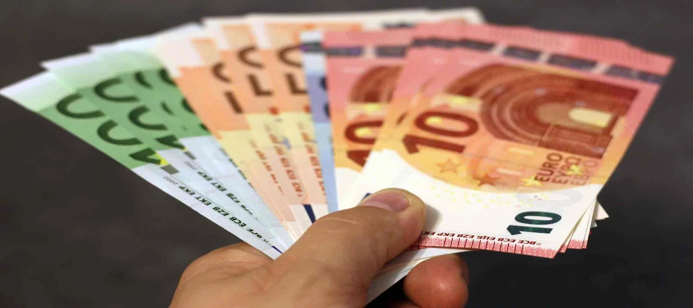 Hand holding a fan of euro banknotes in different denominations
