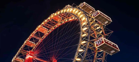 Vienna’s Giant Ferris Wheel illuminated at night with red passenger cabins