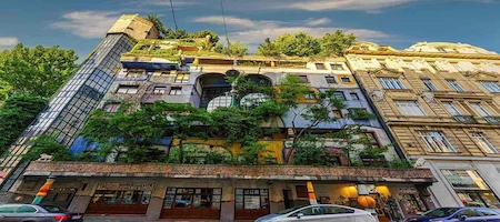 Hundertwasserhaus in Vienna with a colourful façade and trees growing on its terraces