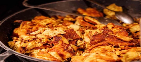 Golden Kaiserschmarrn pancake pieces in a large frying pan