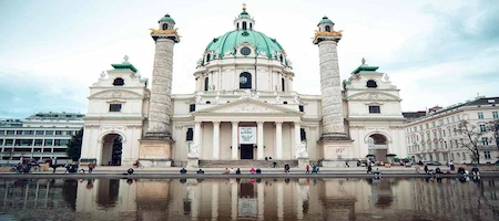 Karlskirche in Vienna with its green dome, twin columns and reflecting pool