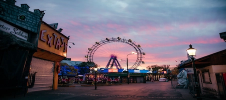 Ferris wheel at Vienna’s Prater amusement park beneath a pink sunset sky