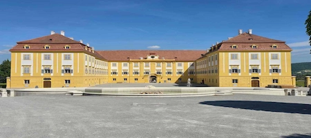 Schloss Hof Palace with its yellow façade and fountain in the forecourt