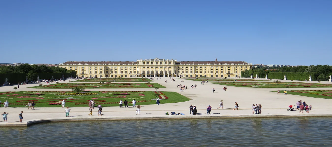Schönbrunn Palace and its formal gardens in Vienna under a clear blue sky