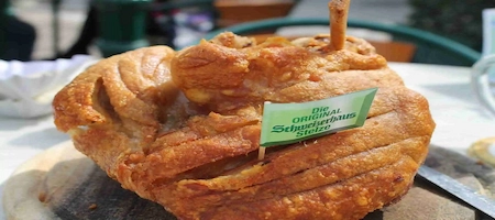 Roasted pork knuckle (Stelze) with crisp golden skin and a Schweizerhaus flag