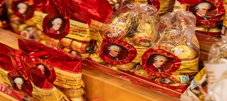 Mozartkugeln chocolates in red and gold gift bags decorated with Mozart portraits
